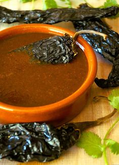 a wooden bowl filled with soup next to dried leaves