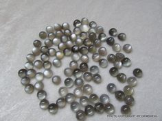 a pile of gray and white pearls sitting on top of a table