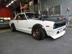 a white car parked in front of a garage