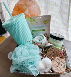 a spa basket with soap, body scrubs and other items in it on a table