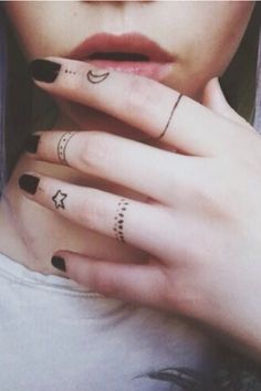 a close up of a person with tattoos on their hands and fingers, holding her hand to her face