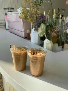 two plastic cups filled with food sitting on top of a counter