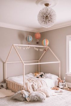 a white bed sitting in a bedroom next to a window with hot air balloons above it