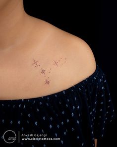 a woman's upper back shoulder tattoo with three stars on her left side,