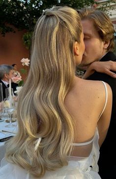 a man and woman kissing each other at a formal event