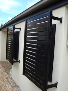 the side of a white house with black shutters