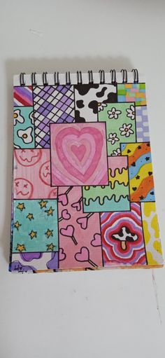 a colorful notebook with many different designs and shapes on it, including a heart in the middle