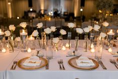 the table is set with white flowers and candles