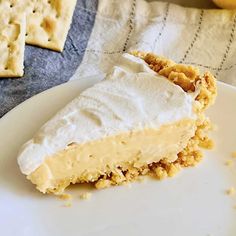 a piece of pie on a plate with some crackers and lemons in the background