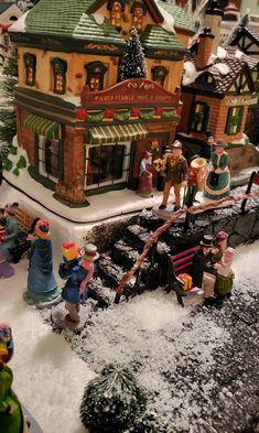 there are many figurines in front of the store on this snowy street corner