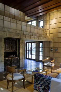 a living room filled with furniture and a fire place next to a wall covered in bricks