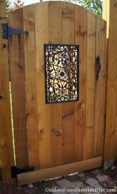 a wooden gate with an iron screen on it