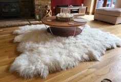 a living room with a white sheepskin rug on the floor and a coffee table