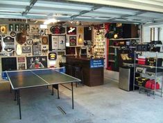 a ping pong table in a garage with lots of memorabilia on the walls and shelves