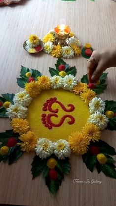 someone is decorating a table with flowers and candles for diwaling the ganeshi