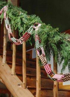 some pine branches are tied to the banisters for christmas decorations on the stairs