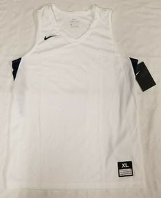 Brand new with defects Nike practice basketball jersey in a boy's size XL. -Acceptable condition with sign of defects, pink marks located on the stomach. -Features: embroidered swoosh logo on the chest, white base color, navy accents, light-weight design. -100% Polyester. -Made in Honduras. *Please review all pictures in this listing for any or all imperfections. Please review measurements listed for physical fitment. Chest width (pit to pit): 18.5" inches Body length (top of shoulder strap to b White Moisture-wicking Basketball Top, White Sleeveless Team Name Tops, White Moisture-wicking Tank Top For Sports, White Moisture-wicking Tank Top For Sports Events, White Jersey Design, Jersey Design Basketball, Practice Basketball, Navy Accents, Jersey Boys