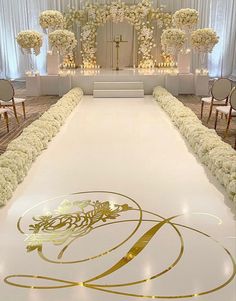 the aisle is decorated with white flowers and gold trim