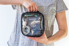 a woman is holding an electronic device in her hand and plugged into the charger