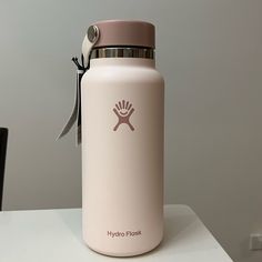 a pink hydro flask water bottle sitting on top of a table