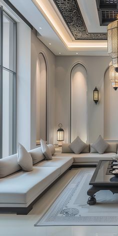 a large living room with white couches and chandelier hanging from the ceiling