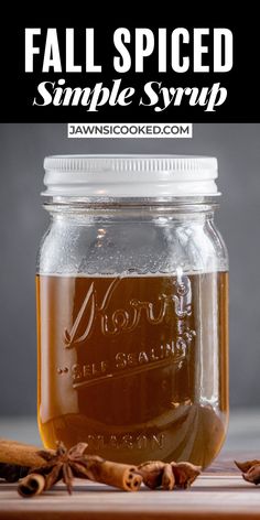 a jar filled with liquid sitting on top of a table next to some cinnamons