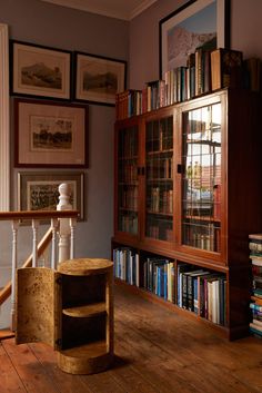 a bookshelf filled with lots of books next to a stair case