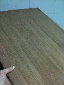 a hand is pointing at the edge of a piece of wood