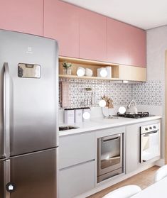 a kitchen with stainless steel appliances and pink cupboards on the wall, along with white chairs