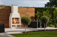 an outdoor fireplace in the middle of a garden