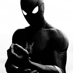 a black and white photo of a spider man holding his hands together in front of the camera