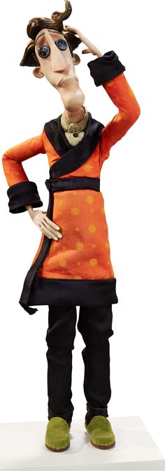 a statue of a woman in an orange and black outfit with her hands on her head