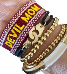 Are you a Sun Devil mom? If so, this bracelet is for you!  Maroon bracelet with gold embroidery.  Self tie. One size fits all Tassel Bracelet, Gold Embroidery, Custom Branding, Braided Bracelets, One Size Fits All, Sale Items, Tassels, Sun, Embroidery