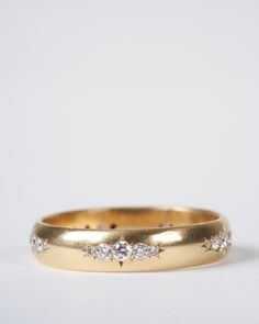 a gold wedding band with five diamonds on the inside and outside, set in 18k yellow gold