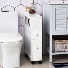 a white toilet sitting next to a wooden cabinet in a bathroom under a tiled wall