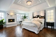 a large white bed sitting in a bedroom on top of a hard wood floor