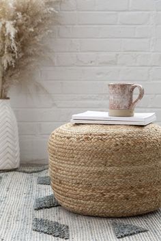 a coffee cup sitting on top of a jute ottoman