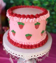 there is a pink cake with strawberries on it