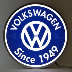 a blue volkswagen sign hanging from the side of a wall