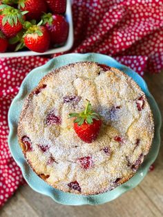 a cake on a plate with strawberries next to it