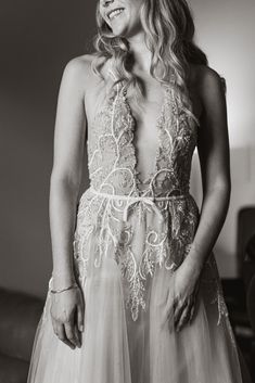 a black and white photo of a woman in a wedding dress looking at the camera