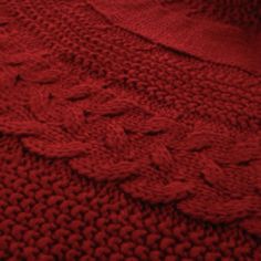 a red knitted blanket is laying on the floor