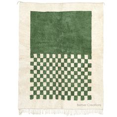 a green and white rug with checkered squares on the front, fringes at the bottom