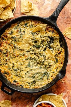 tortilla dip in a cast iron skillet with tortilla chips on the side