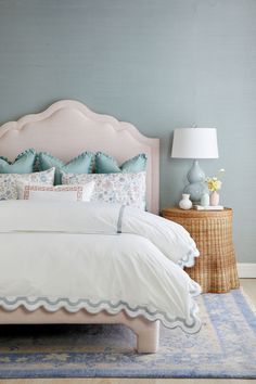 a bedroom with blue walls and white bedding