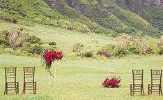 the chairs are set up with flowers on them for an outdoor wedding ceremony in front of a mountain range