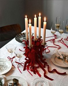 a table topped with lots of candles and plates