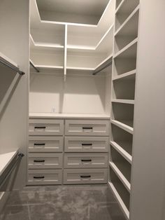 an empty walk in closet with drawers and shelves