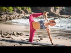 a woman is doing yoga on the beach