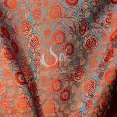 an orange and blue fabric with red flowers on it